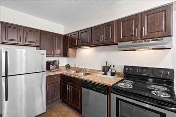 A kitchen with a stove, refrigerator, and microwave. at Malvern Hill Apartment Homes, Kansas